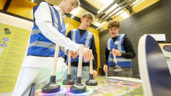 Jugendliche beim Ausprobieren des Spielbretts mit Pümpeln