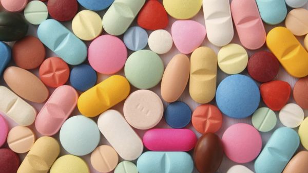 Bunte Tabletten, rund, oval, dreieckig in verschiedenen Größen. Manche in 2 oder 4 Teile zu brechen mit Kerben zum leichteren Teilen. Eine braune und schwarze Medikamentenkapsel.