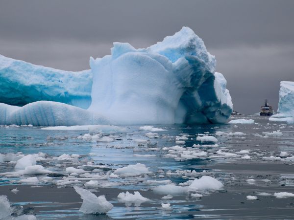 Eisbrecher neben riesigen Eisblöcken in der Antarktis