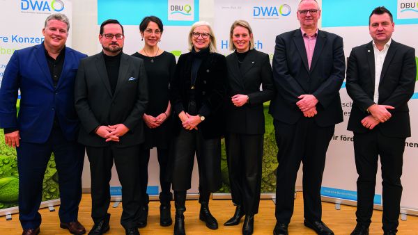 Sieben Teilnehmer und Teilnehmerinnen stehen vor Roll Ups. Es sind Personen, die am parlamentarischen Abend der DWA und DBU teilgenommen haben