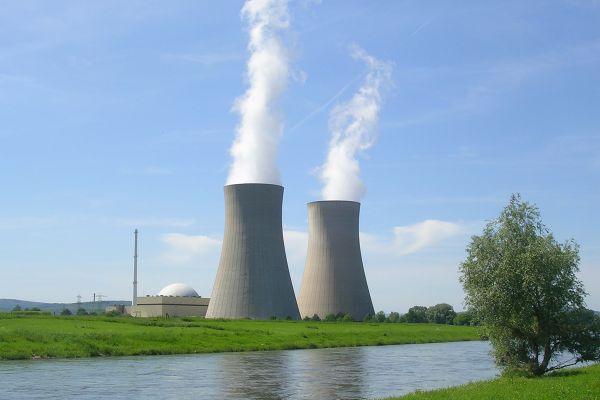 Kraftwerk an der Weser mit 2 Kühltürmen, aus denen Wasserdampf austritt.