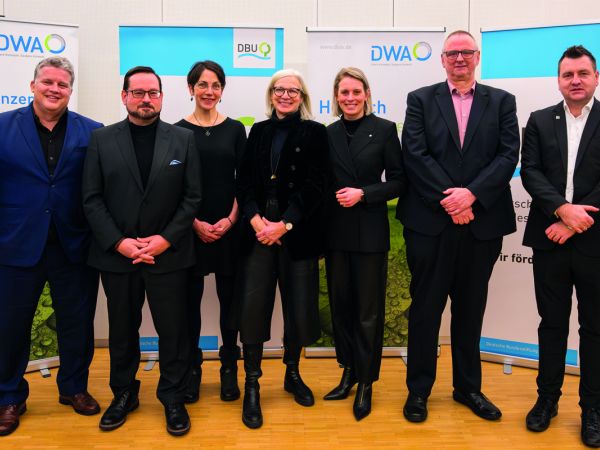 Sieben Teilnehmer und Teilnehmerinnen stehen vor Roll Ups. Es sind Personen, die am parlamentarischen Abend der DWA und DBU teilgenommen haben