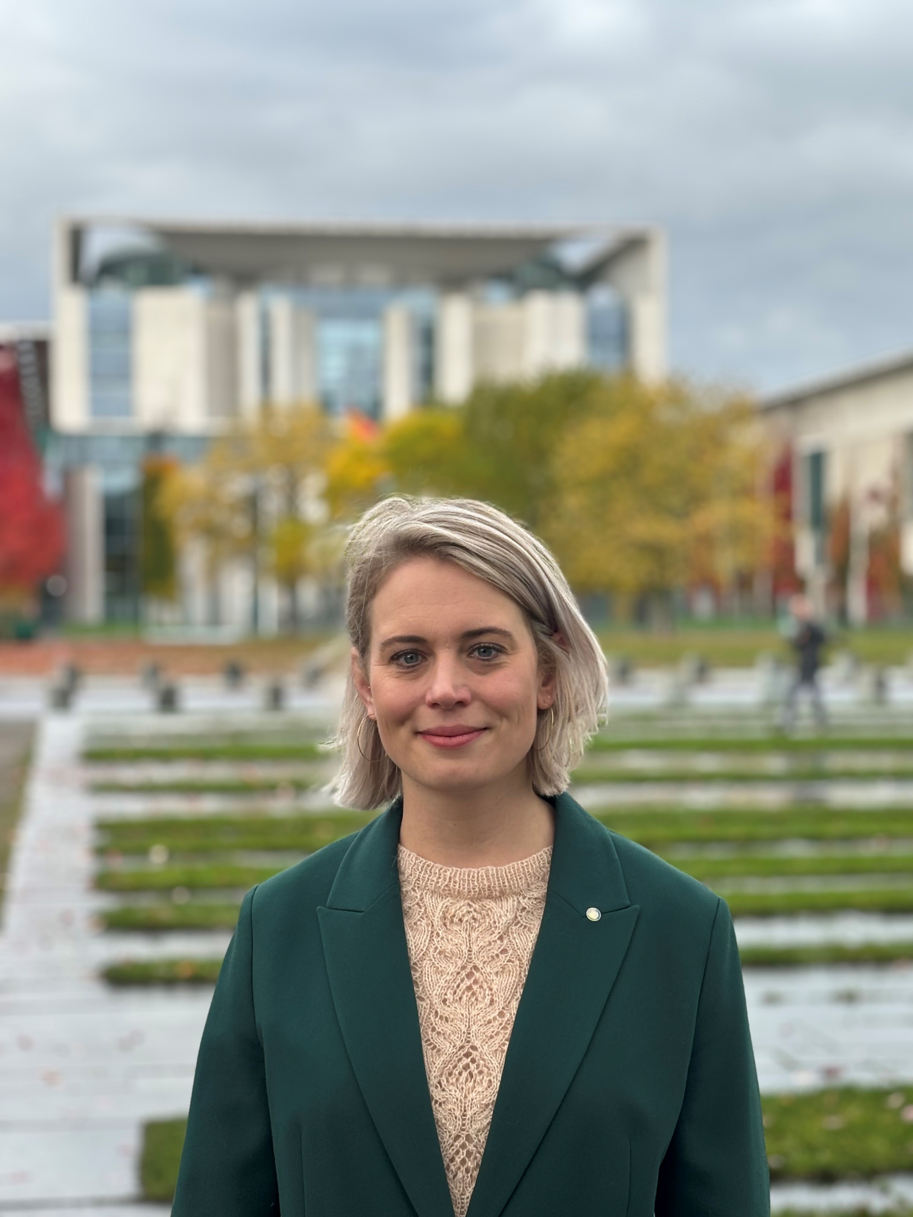 Portrait Frau Dr. Lisa Broß vor dem Bundeskanzleramt